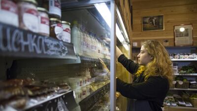 An employee stocks shelves at a farmers' food store in Moscow. Some Russian farmers and retailers have thrived thanks to the Kremlin’s ban on Western food, seizing the market niche previously occupied by imports. Alexander Zemlianichenko/AP Photo