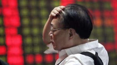 An investor reacts as he looks at the stock price monitor at a private securities company in Shanghai.