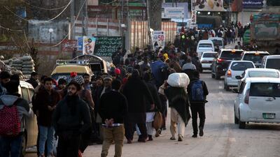 Stranded tourists make their way home from Murree. EPA