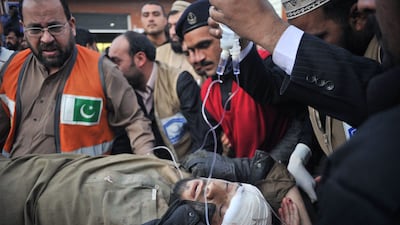 Pakistani paramedics transport a bomb blast victim to a hospital in Peshawar on December 29. AFP Photo