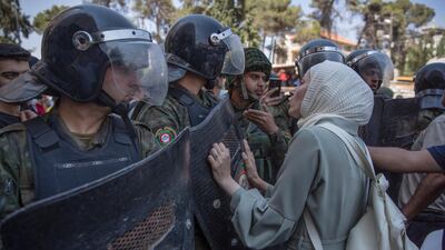 Angry demonstrators carry pictures of Nizar Banat, an outspoken critic of the Palestinian Authority, and chant anti-PA slogans during a rally protesting his death, in the West Bank city of Ramallah. AP