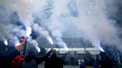 Ukrainian far-right group activists hold flares in Kiev as they block work at a huge shopping mall "Ocean Plaza" belonging to Russian business man and oligarch Boris Rotenberg, a figure close to President Vladimir Putin. AFP