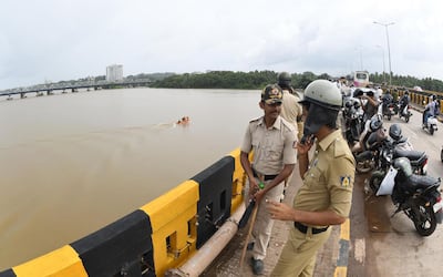 Police stand on a bridge overlooking the Netravati river near Mangalore, Karnataka. AFP