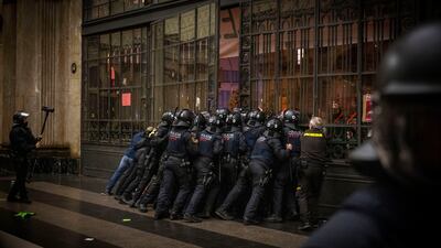 Police try to contain protesters trying to enter the train station in Barcelona. AP