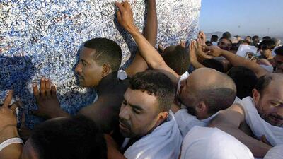 Pilgrims performing Hajj in January 2004 touch the monument at the summit of Jabal Arafat, where the Prophet Mohammed gave his last sermon.