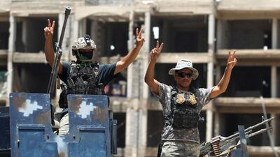 Iraqi government forces flash victory signs after gains against ISIL in Fallujah on June 10, 2016, as the extremists lost a vital supply line in neighbouring Syria. Ahmad Al Rubaye / AFP