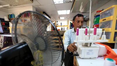 Shakeel Ahmed, a tailor at Josh Couture, works with a fan facing him as the building's air-condition is not up to the task. Ravindranath K / The National