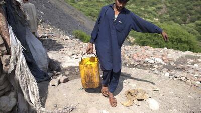 Samiullah, who says he is 14 years old, carries water for his uncle’s bath at a coal field in Choa Saidan Shah, Punjab. Although Pakistan has introduced legislation to deal with child labour, the problem is deeply entrenched in society. Sara Farid / Reuters