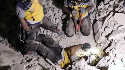 Rescue workers known as White Helmets break concrete during a search for survivors following Syrian government forces air strikes in Orum al-Kubra, in the northern province of Aleppo on August 10, 2018. AFP