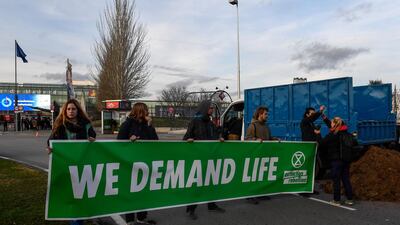 Activists from international climate action group Extinction Rebellion hold a banner reading "we demand life" after dumping manure outside the UN Climate Change Conference COP25. AFP