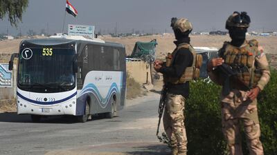 Iraqi soldiers secure buses transporting displaced families from the displaced persons camp in Habbaniyah in Iraq's Anbar province on November 10, 2020. AFP