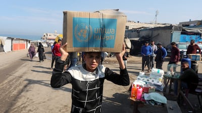 A Palestinian carries an aid box distributed by UNRWA in Deir Al Balah. Reuters
