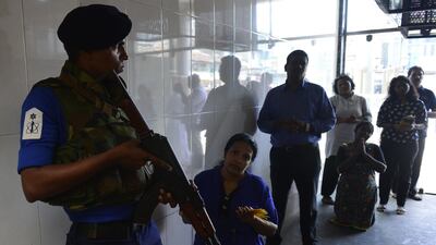 A Sri Lankan Navy personnel stands guard as Catholic devotees pray at St. Anthony's church after it was partially opened for the first time since the Easter Sunday attacks in Colombo on May 7, 2019. AFP