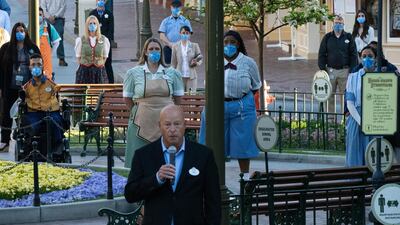Workers wearing protective masks stand behind Bob Chapek, chief executive officer of Walt Disney Company, as he speaks during the reopening of the Disneyland theme park in Anaheim, California, US, on Friday, April 30, 2021. Bloomberg