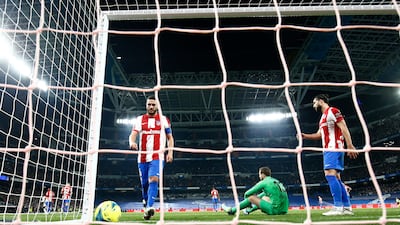 Atletico Madrid players look dejected after Asensio's goal. Reuters