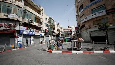 A vendor sits on a sidewalk as shops in the West Bank city of Ramallah shuttered on April 27, 2017 during a general strike in solidarity with Palestinian prisoners on hunger strike in Israeli jails. Mohamad Torokman/Reuters