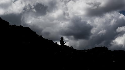 In this photo taken Wednesday, Dec. 5, 2018, a young boy who scavenges for recyclable materials for a living throws a rock in the air to pass the time as he takes a break while sitting on top of a mountain of garbage at the dump in the Dandora slum of Nairobi, Kenya. As the world meets again to tackle the growing threat of climate change, how the continent tackles the growing solid waste produced by its more than 1.2 billion residents, many of them eager consumers in growing economies, is a major question in the fight against climate change. (AP Photo/Ben Curtis)