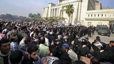 Riot police form a cordon as thousands of Mohammed Morsi’s supporters surround the Supreme Constitutional Court yesterday to prevent judges from entering and ruling on the legitimacy of the nation's Islamist-dominated constituent assembly.