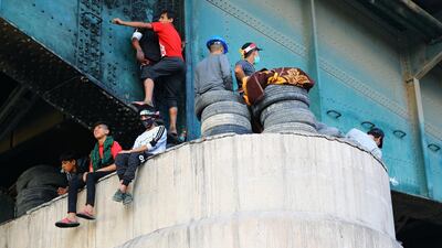 Iraqi demonstrators climb Al Jumhuriya bridge during the ongoing anti-government protests in Baghdad. Reuters
