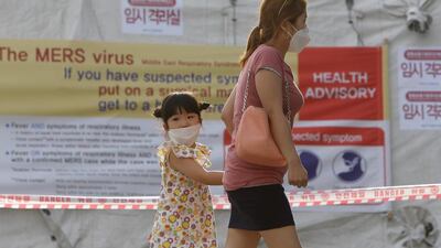 Visitors wearing masks walk past a health advisory sign warning about the Mers virus outside a quarantine tent at Seoul National University Hospital in Seoul on June 2, 2015. Chung Sung-Jun/Getty Images)
