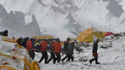 Rescue team personnel carry an injured person towards a rescue helicopter at Everest Base Camp on April 26, 2015, a day after an avalanche triggered by an earthquake devastated the camp. Roberto Schmidt/AFP Photo