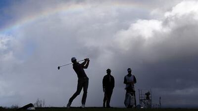 Dustin Johnson hits a tee shot under a rainbow as the Tournament of Champions finally begins in Hawaii.