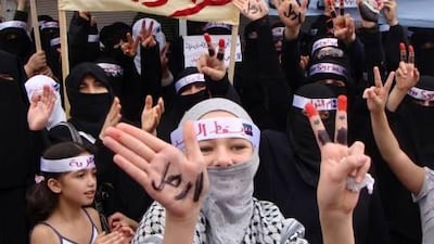 Anti-Assad protesters flash V-victory signs as a woman uses her hands to display the Arabic word reading: 'leave', during a demonstration in Syria. Business chiefs are now attempting to overturn an imports ban as more international economic sanctions loom against the embattled Assad regime.