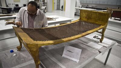 Egyptian archaeologist Medhat Abdallah, cleans a gold-plated bed from Tutankhamen's treasures at the new Grand Egyptian Museum near the Giza pyramids in Cairo on June 4, 2015. Khaled Desouki/AFP Photo