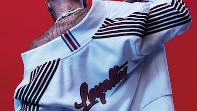 A white tracksuit with velvet stripes on the arm and leg seams nd the world loyalty, inspired by Lewis' own tattoo, on the back. Courtesy Tommy Hilfiger