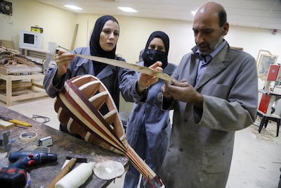 Two students learn to make a lute, in Nablus, in the occupied West Bank, on November 7, 2021. Reuters