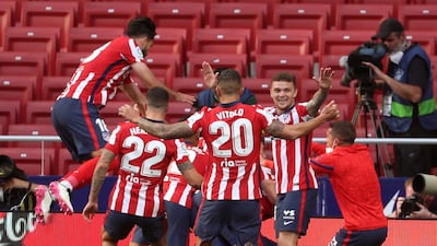 Atletico Madrid players celebrate with Luis Suarez after his winning goal against Osasuna. EPA