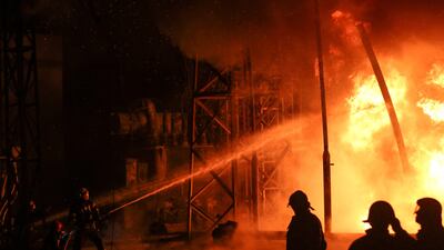 Firefighters work at a site of the fifth thermal power plant damaged by a Russian missile strike. Photo: Reuters