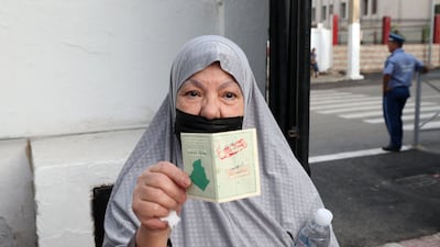 An voter shows the proof of her ballot outside a polling station in Algiers. AFP