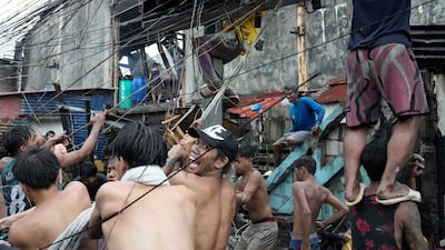 Residents salvage electrical wire which they will sell later after a fire hit a poor community in Manila, the Philippines. AP