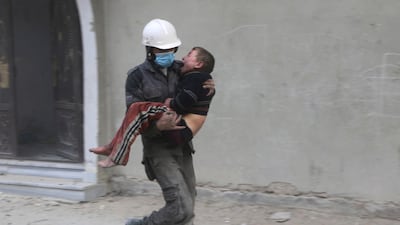 File photo of a member of the White Helmets carrying a boy wounded during airstrikes and shelling by Syrian government forces, in Ghouta, a suburb of Damascus. AP
