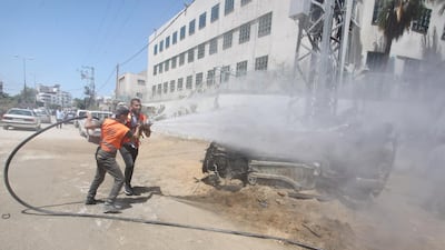 Volunteers use a hose during the clean-up as part of the Han'amerha (we will rebuild it) campaign.