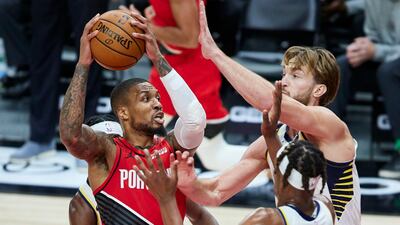 Portland Trail Blazers guard Damian Lillard, left, drives to the basket toward Indiana Pacers forward Domantas Sabonis. AP