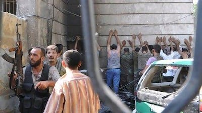 Free Syria Army opposition fighters guard a group of detained policemen after overrunning the Shaar district police post in Aleppo.
