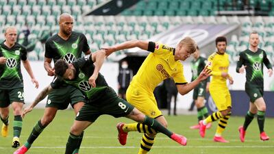 Borussia Dortmund's Erling Haaland takes on Wolfsburg's Renato Steffen. Reuters