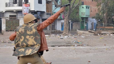 A police personnel aims his gun towards protesters during demonstrations against India's new citizenship law in in Kanpur. AFP