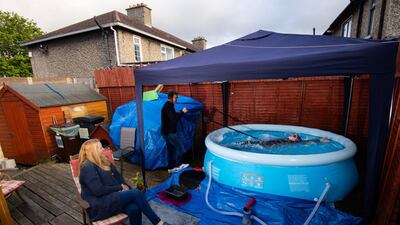 Swimmer Mia Whelan-O'Connor of ESB Swimming Club swims in her back garden in an inflatable pool, in Inchicore, Dublin, using a swimming parachute and a bungee cord with the assistance of her dad Michael and mother Carol. Getty