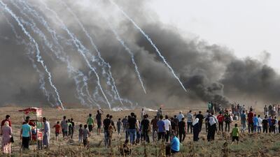 Protesters walk toward the fence where the Israeli troops fire teargas while others burn tires near the fence of the Gaza Strip border with Israel, during a protest east of Gaza City. AP Photo