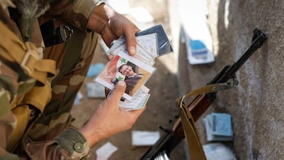 A Syrian soldier searches through documents outside the Mezzeh airbase, near Damascus, after rebels ousted president Bashar Al Assad. EPA