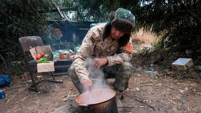 A fighter loyal to the Government of National Accord (GNA) cooks at their base in the capital Tripoli. AFP
