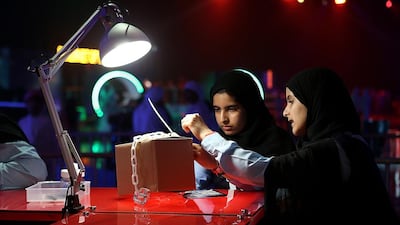 Rouda Yousef, left, and El Yazi Ismaeil of Al Maha School take part in the ‘tamper evident’ during the Cyber Quest event and contest at Adnec in Abu Dhabi. Satish Kumar / The National