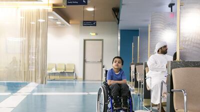 Abdullah Nehayan Al Suwaidi, 5, sits in Al Towayya Children’s Specialty Center reception with his father. He has an ear infection. Reem Mohammed / The National