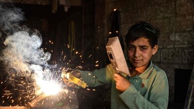 A young Syrian boy works at a car repair shop in the town of Jandaris, in the countryside of the north-western city of Afrin in the rebel-held part of Aleppo province, a day before the annual World Day Against Child Labour.