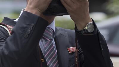 A member of the North Korean media takes a photograph outside the St. Regis hotel in Singapore, on Sunday, June 10. Two staff from South Korea's national broadcaster have been deported from Singapore after they were arrested for trespassing at the home of the North Korean ambassador to the city-state. Brent Lewin / Bloomberg