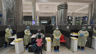 Health workers wait to screen passengers on a London to Dubai flight. AFP