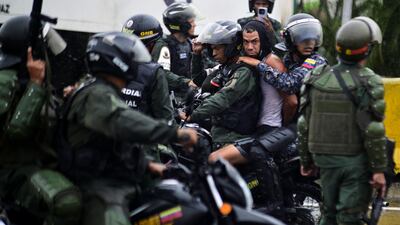 A demonstrator is detained by riot police in Caracas. Reuters